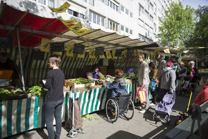 Marché d'Alésia , une femme en fauteuil faisant sont marché (Sophie Robichon / Ville de Paris)